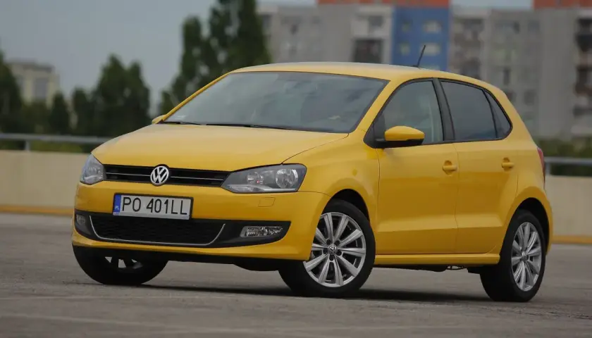 Żółty Volkswagen Polo na parkingu, idealny do miasta. Zastanawiasz się, ile pali ten model?