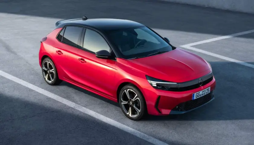 Czerwona Opel Corsa z czarnym dachem na parkingu. Zastanawiasz się, ile pali Opel Corsa? Ten model jest oszczędny.