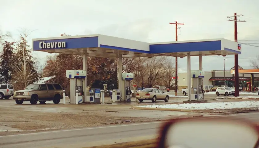 Stacja Chevron, samochody na zimowym parkingu. Zastanawiasz się, ile kosztuje jeden galon benzyny w USA?