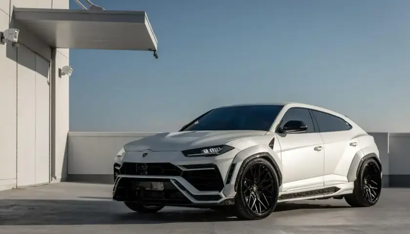 Biały Lamborghini Urus z czarnymi felgami, gotowy do galopu. Zastanawiasz się, ile koni ma Urus? Ten potwór ma ich 650!