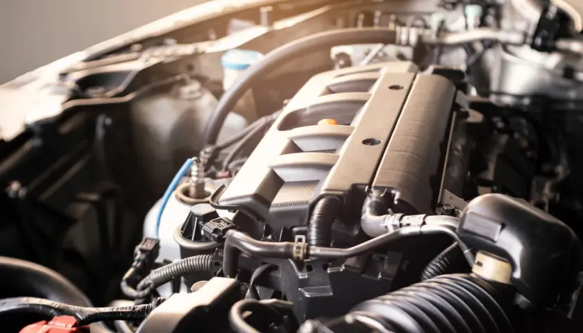 Zbliżenie na silnik samochodowy BMW E91, widoczne przewody i elementy mechaniczne.