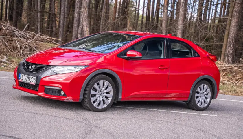 Czerwony Honda Civic IX na tle lasu.