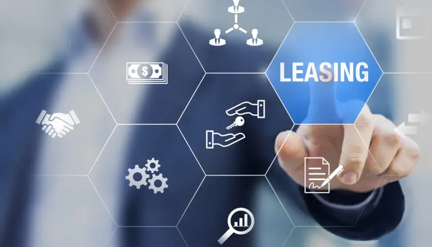 Dłoń dotyka ekranu z ikonami symbolizującymi leasing, pieniądze, klucze i umowę.