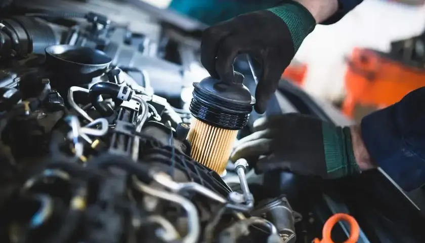 Mechanik wymienia filtr paliwa w silniku. Pamiętaj, co ile się wymienia filtr paliwa, by auto działało sprawnie.