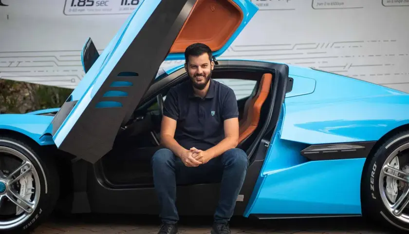 Młody mężczyzna siedzi w błękitnym Bugatti. Czy to on jest właścicielem tego cudu techniki?
