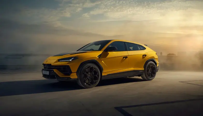 Żółty Lamborghini Urus na tle zachodzącego słońca. Ten SUV ma moc 650 KM, co czyni go potężnym zwierzęciem na kołach.