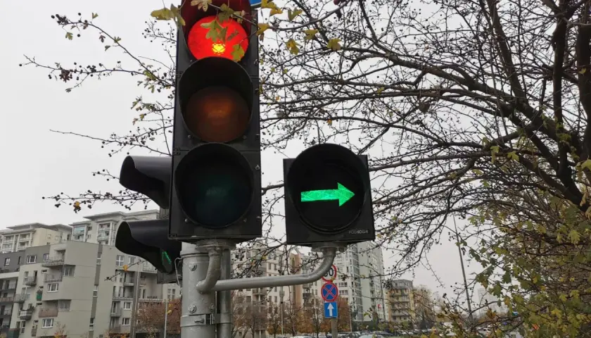 Sygnalizacja świetlna: czerwone światło na głównym sygnalizatorze i zielona strzałka w prawo na dodatkowym.