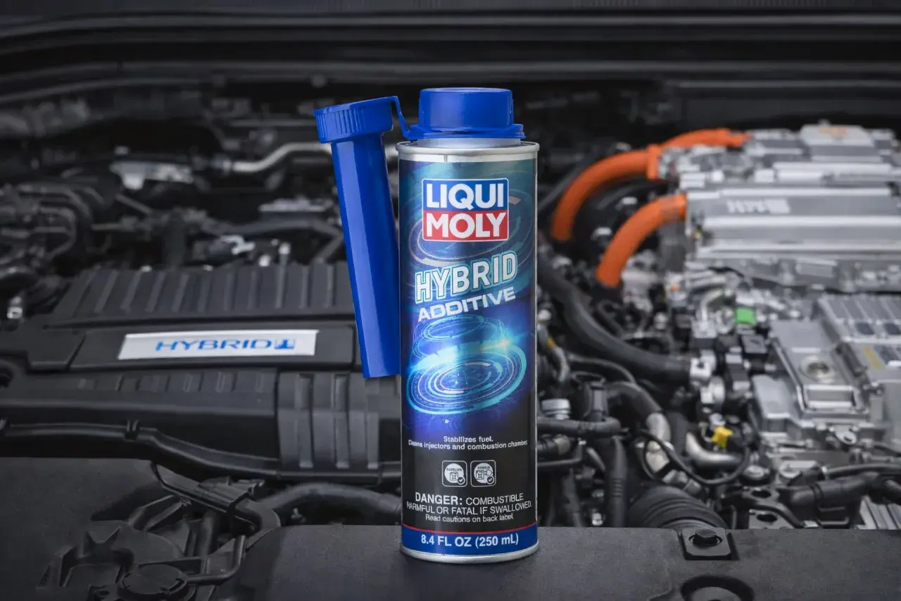 Dodatek do diesla Liqui Moly Hybrid Additive w puszce, na tle silnika hybrydowego. Dba o czystość układu paliwowego.