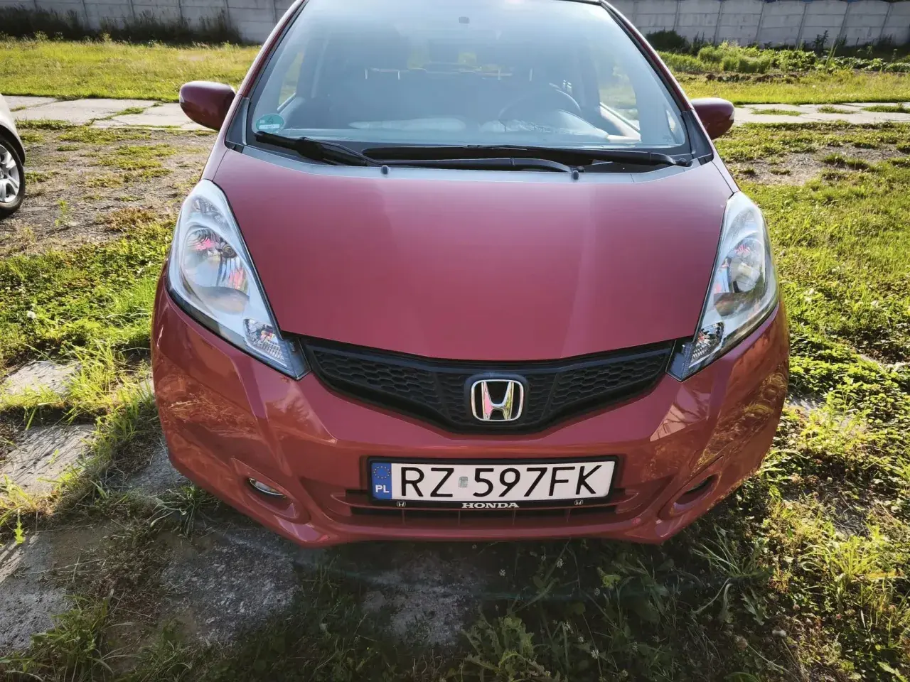 Czerwona Honda Jazz z tablicą RZ 597FK. Zastanawiasz się, jaki olej do Hondy Jazz 1.4 benzyna? Ten model zasługuje na najlepszy!
