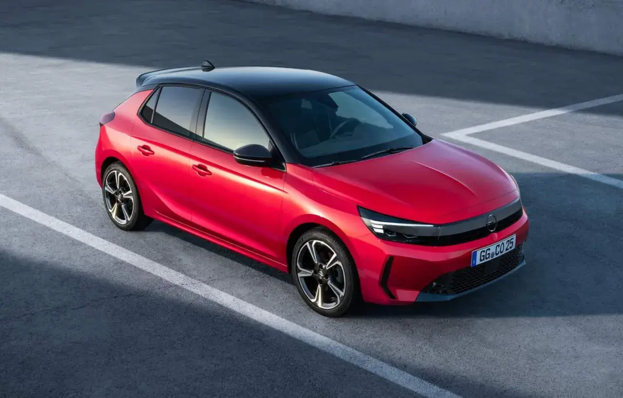 Czerwona Opel Corsa z czarnym dachem na parkingu. Zastanawiasz się, ile pali Opel Corsa? Ten model jest oszczędny.