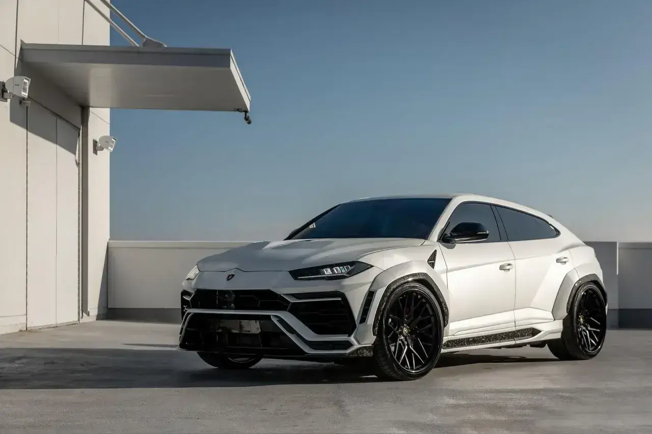 Biały Lamborghini Urus z czarnymi felgami, gotowy do galopu. Zastanawiasz się, ile koni ma Urus? Ten potwór ma ich 650!