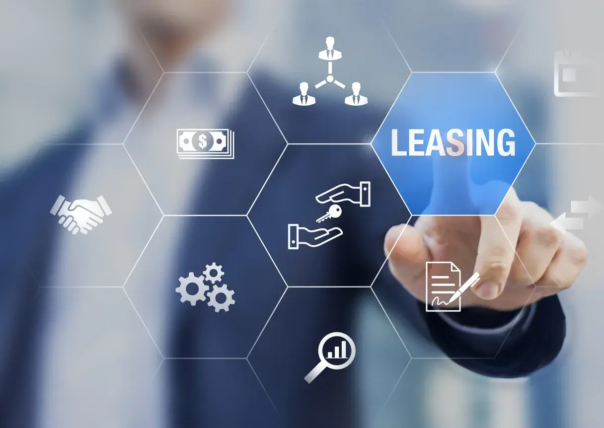 Dłoń dotyka ekranu z ikonami symbolizującymi leasing, pieniądze, klucze i umowę.
