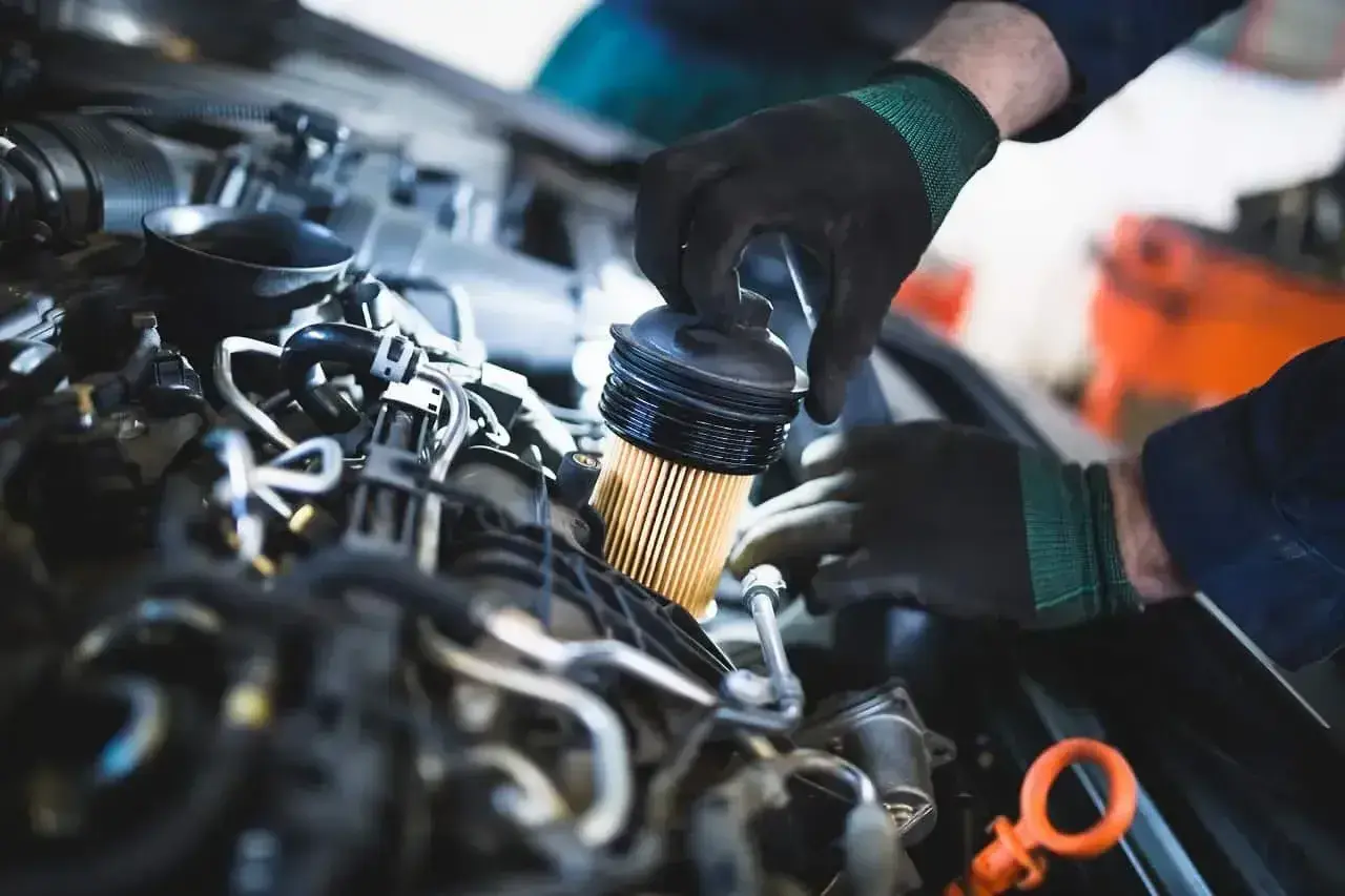 Mechanik wymienia filtr paliwa w silniku. Pamiętaj, co ile się wymienia filtr paliwa, by auto działało sprawnie.