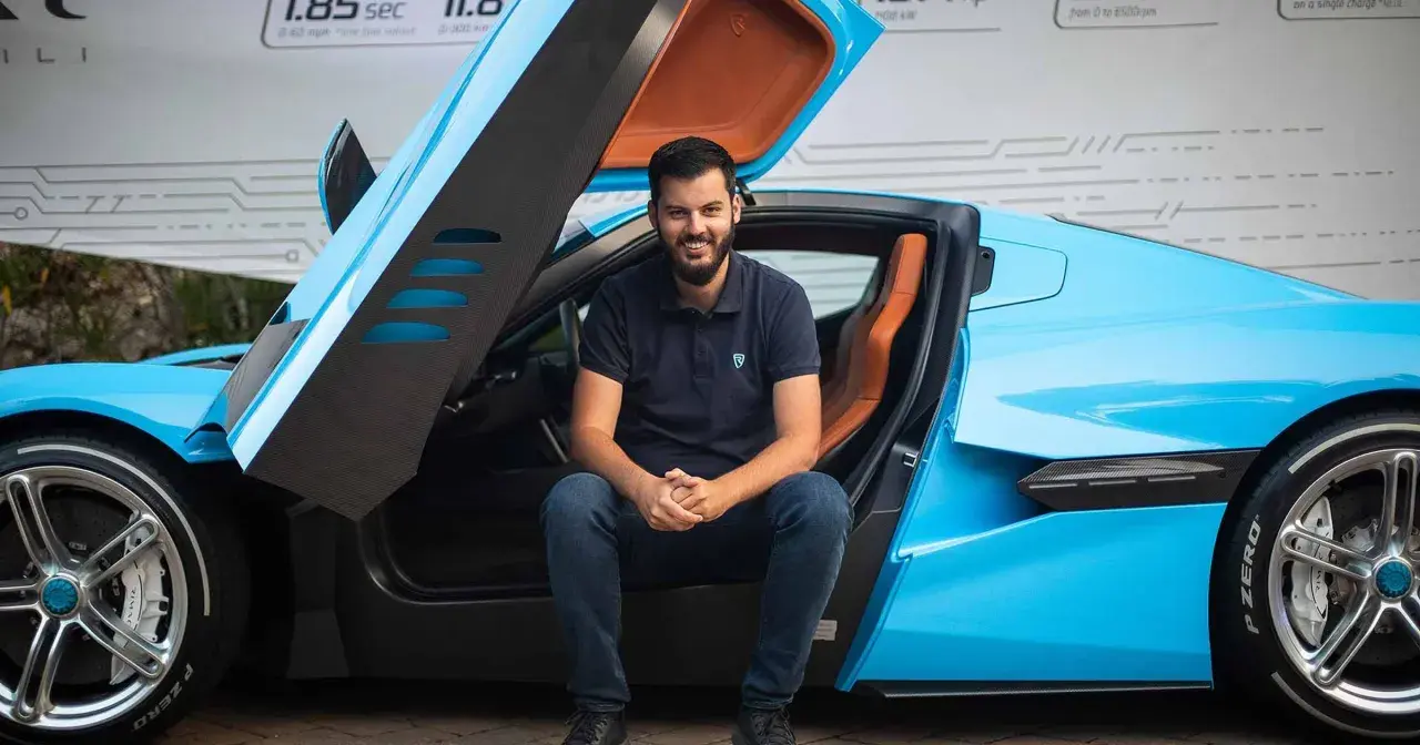 Młody mężczyzna siedzi w błękitnym Bugatti. Czy to on jest właścicielem tego cudu techniki?