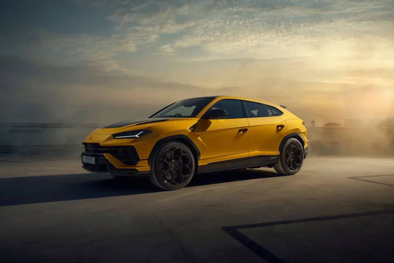 Żółty Lamborghini Urus na tle zachodzącego słońca. Ten SUV ma moc 650 KM, co czyni go potężnym zwierzęciem na kołach.