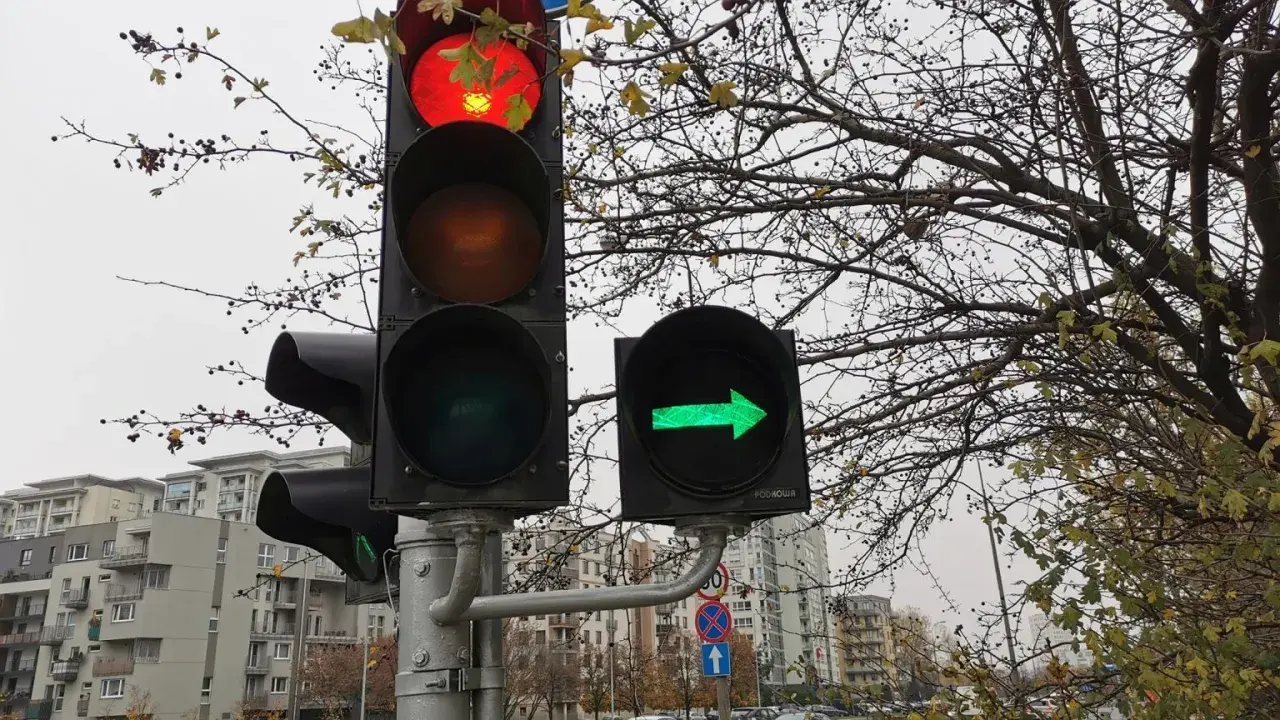Sygnalizacja świetlna: czerwone światło na głównym sygnalizatorze i zielona strzałka w prawo na dodatkowym.