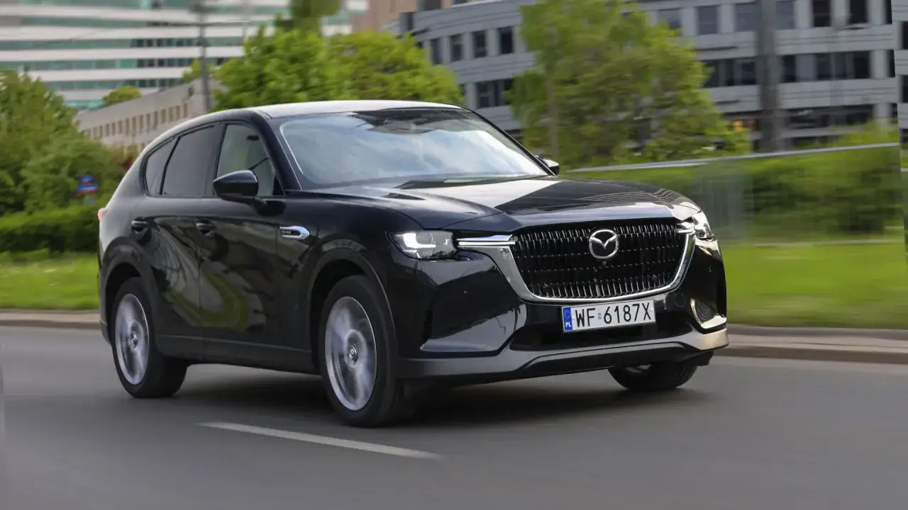 Czarna Mazda CX-60 3.3 diesel w ruchu miejskim, z widocznym grillem i światłami LED.