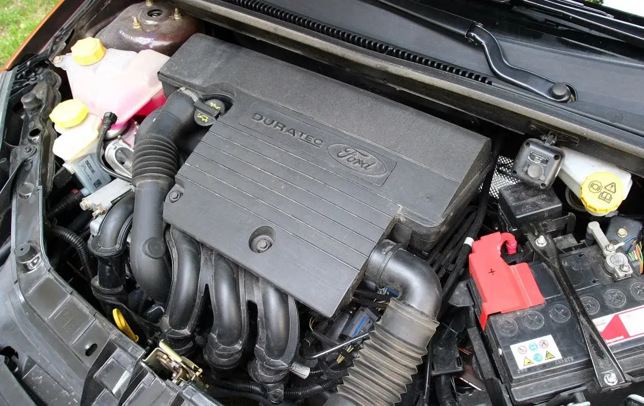 Silnik Duratec w Ford Fiesta MK5. Widoczne elementy układu chłodzenia, akumulator i przewody.