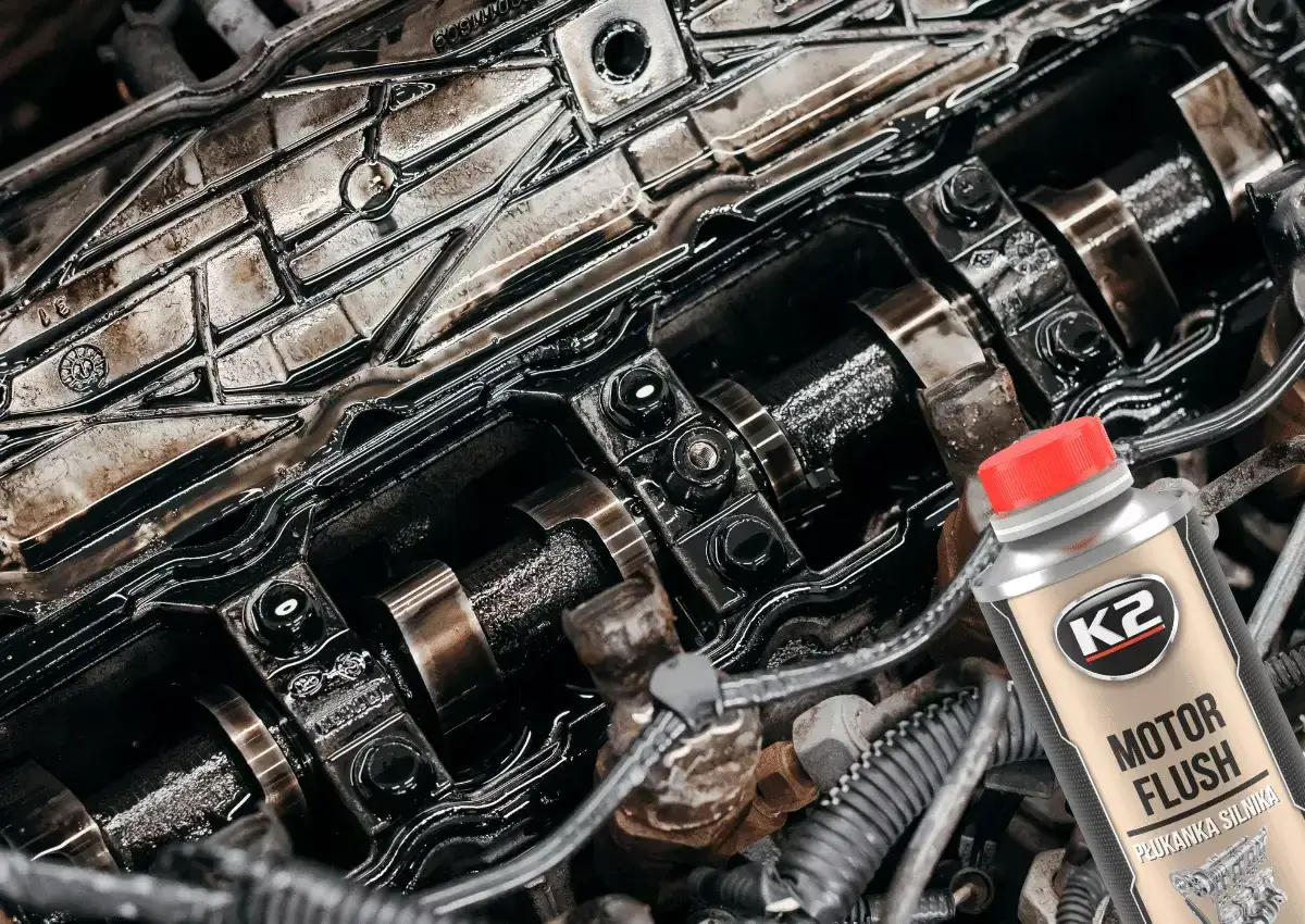 Brudny silnik samochodowy i butelka płukanki do oleju K2 Motor Flush. Czas na czyszczenie!