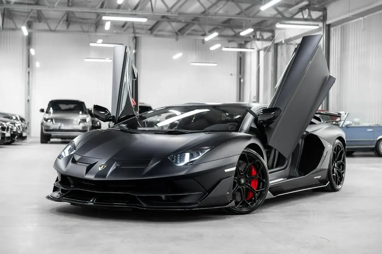 Matowy czarny Lamborghini Aventador SVJ z otwartymi drzwiami. Zastanawiasz się, ile kosztuje Lamborghini Aventador SVJ?