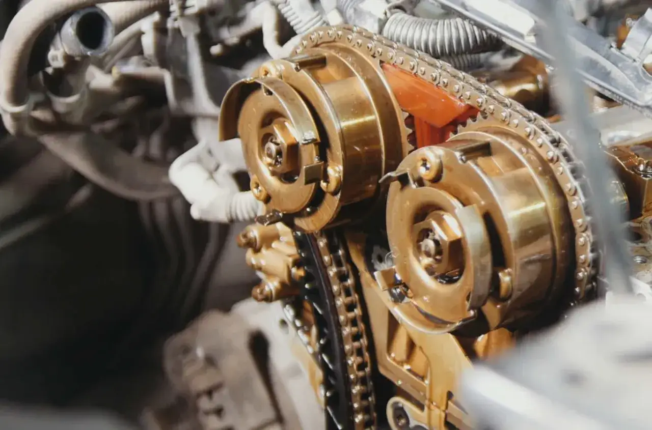 Zbliżenie na mechanizm rozrządu silnika samochodowego. Zastanawiasz się, co ile powinno się wymieniać rozrząd? Sprawdź zalecenia producenta!