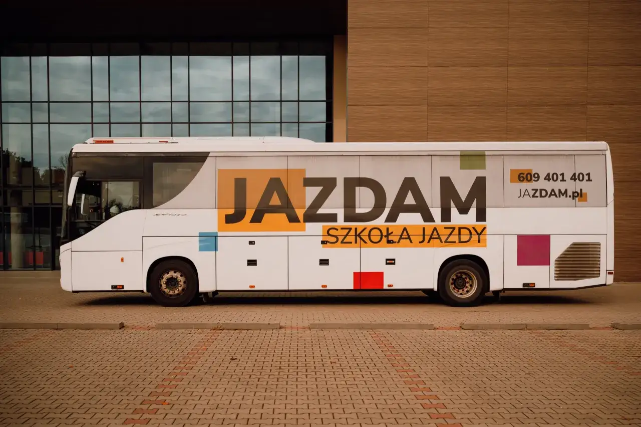 Biały autobus szkolny z napisem 