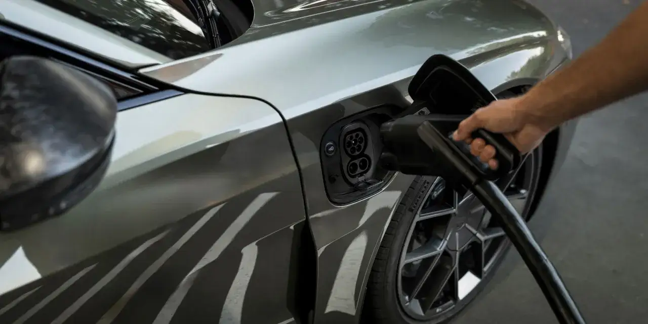 Dłoń podłącza ładowarkę do Audi e-tron GT. Elektryczna moc dla przyszłości.