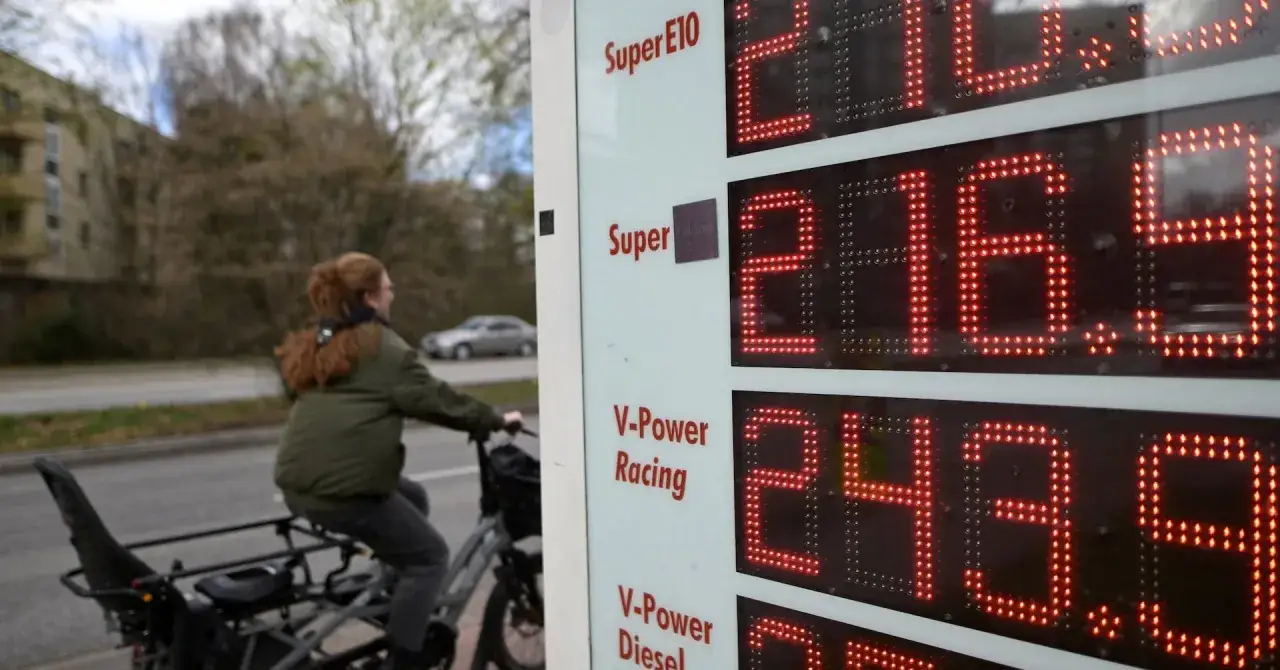 Cena litra diesla w Niemczech to 2,439 €. Kobieta na rowerze mija dystrybutor paliwa.
