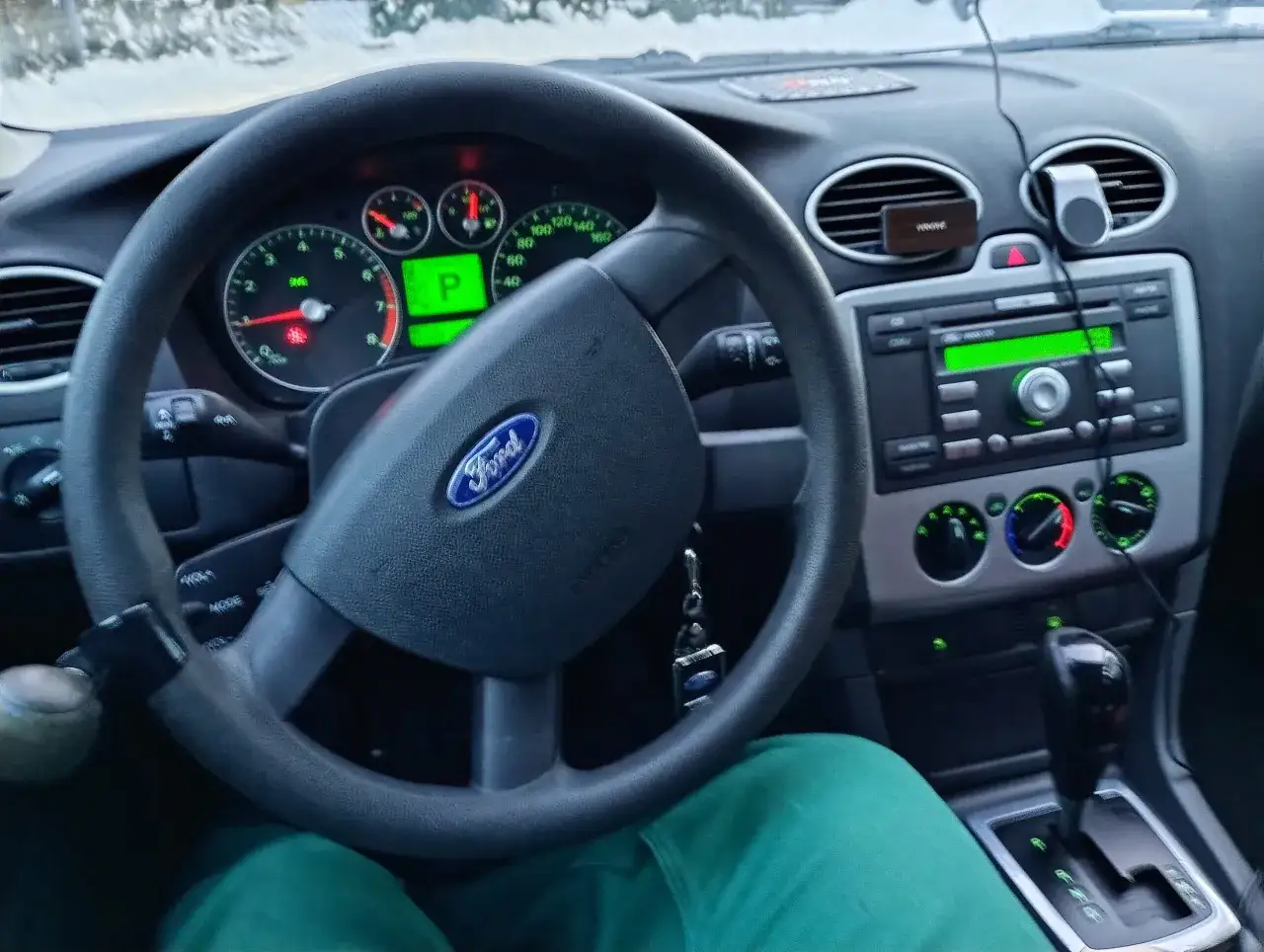 Wnętrze Ford Focus MK2 1.6 benzyna. Widok na kierownicę, deskę rozdzielczą z radiem i automatyczną skrzynię biegów.