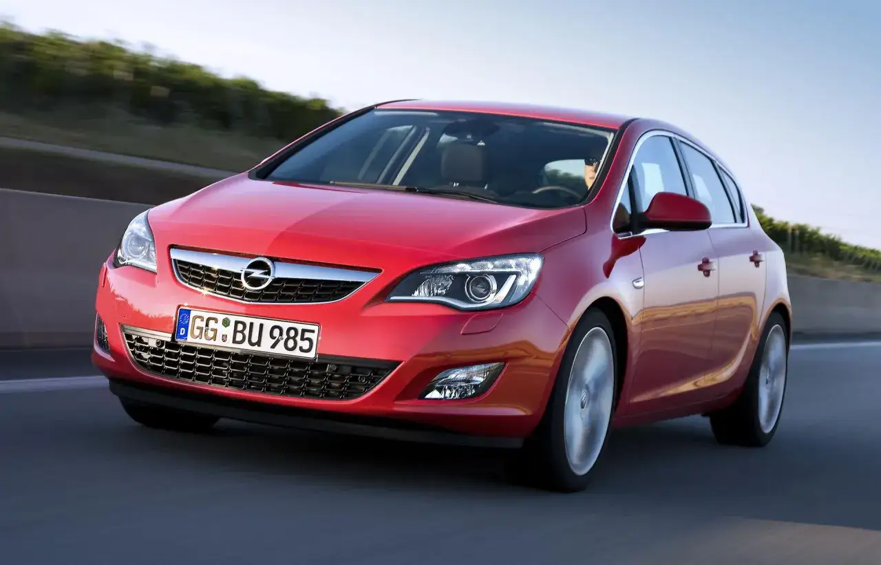 Czerwona Opel Astra jedzie po drodze. Zastanawiasz się, ile pali Opel Astra? Ten model jest znany z oszczędności.