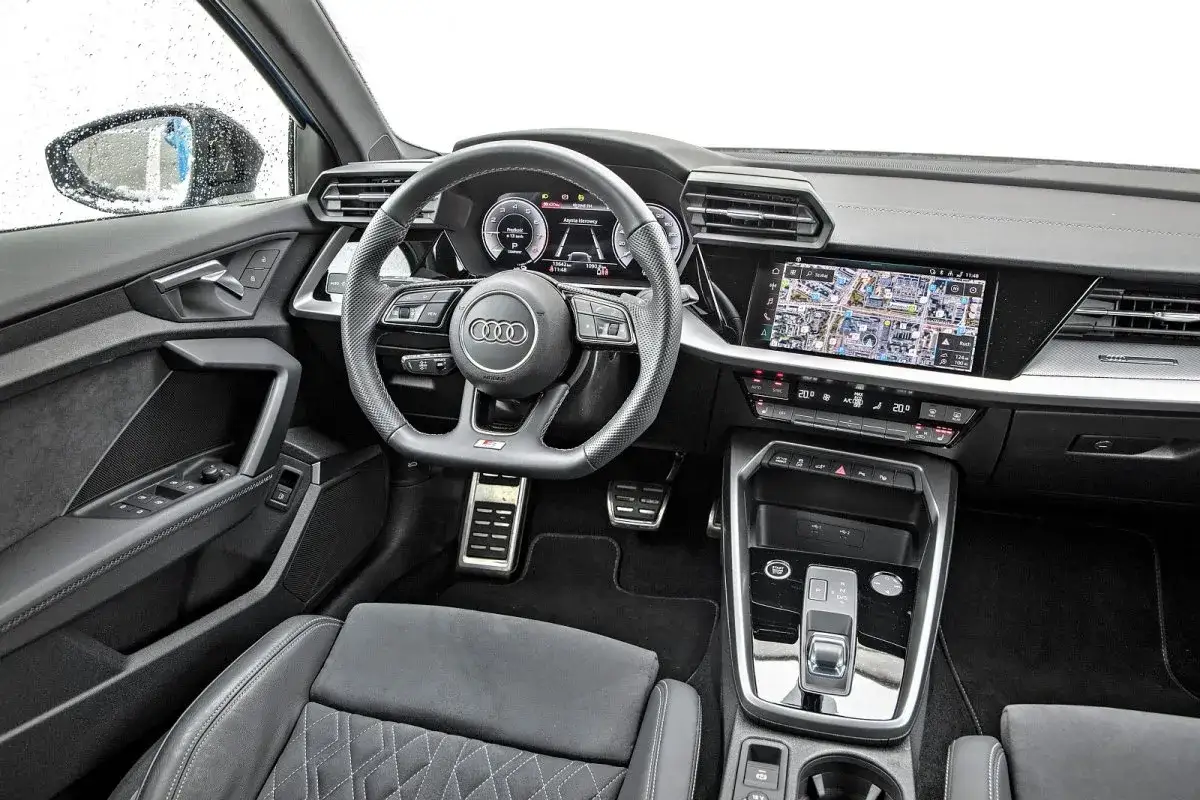 Wnętrze Audi A3 2025: cyfrowy kokpit, ekran multimedialny z nawigacją, sportowa kierownica i eleganckie detale.