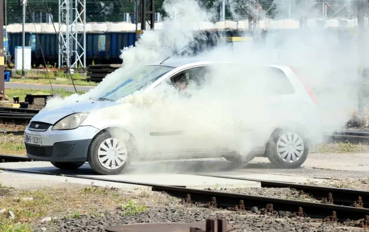 Srebrny Ford Fiesta z silnikiem diesla w obłokach dymu, jakby wpadł w poślizg.